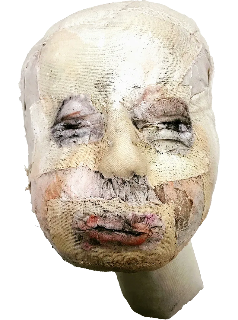 A sculpted bare head with many needle stitches and fabric patches