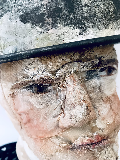 Head sculpture with a head piece of three stacked laboratory sieves