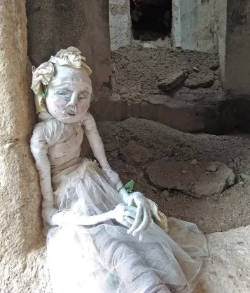 Human woman sculpture at the entrance of a derelict cave