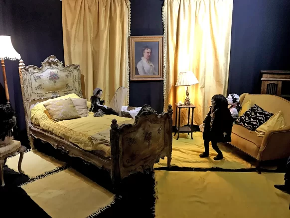 Central view into a bedroom with dominant yellow colour design with four human-like sculptures.